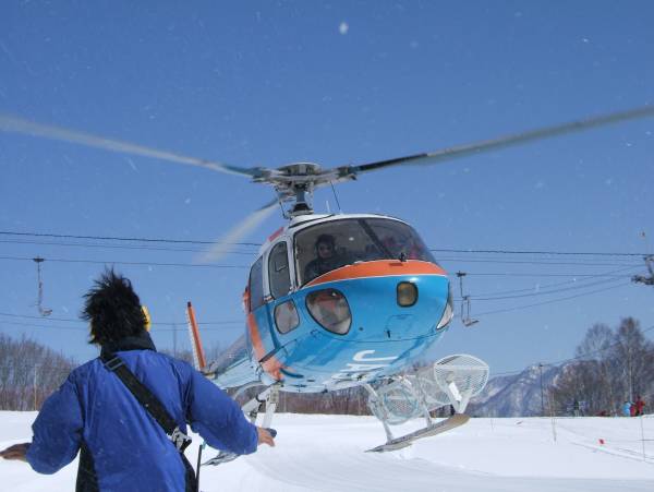 雪の広場前のヘリポートに着陸するヘリ(AS3505)